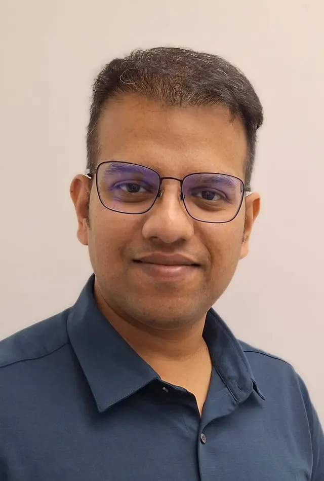 Dr Sunil Akula, implant dentist, smiling in a warm, professional portrait
